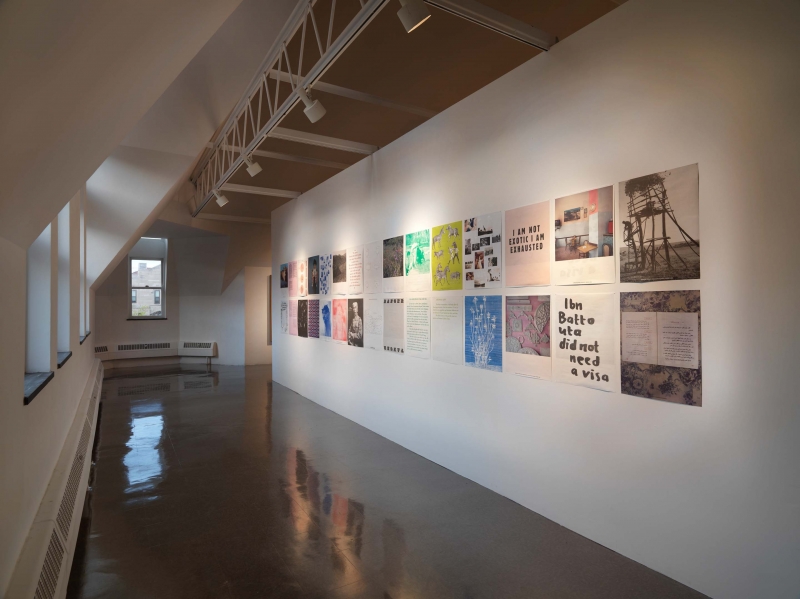 Four color photographs mounted on a wall in the center of the gallery