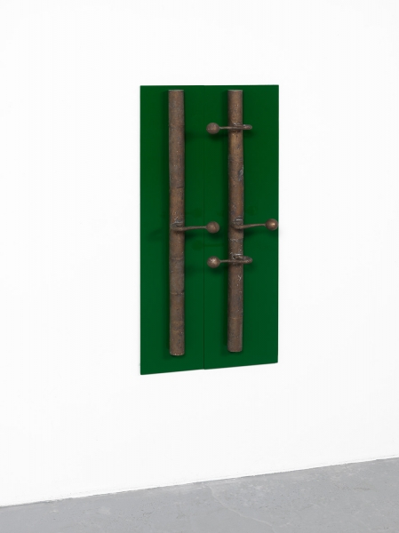 A stand of yellow cherrywood mounted on a wall with a small white, red and aluminum sculpture on top of it