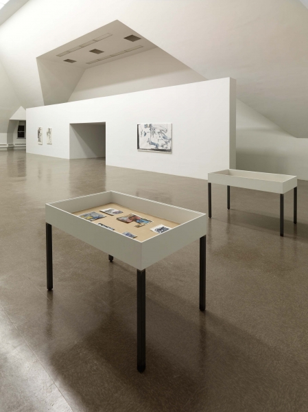 A thin white painting, with black lines, blue and dark gray smears leaving a triangle of white space at bottom left