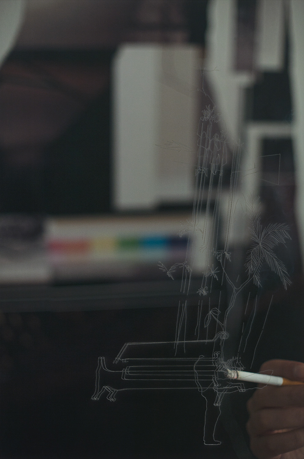 A hand holds a cigarette near a gray outline hanging in mid-air.